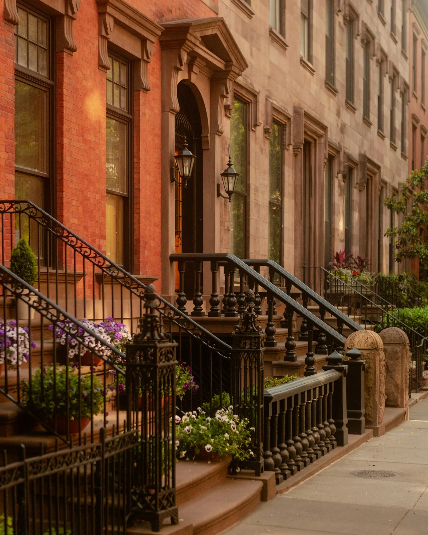 New York City brownstone row with ornate iron railings and flowers